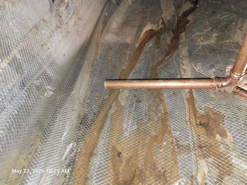 Responded to customer report of water pooling in yard with additional leaking shower head and toilet shut-off valve. Investigated attic space and located copper waterline connections above insulation. Excavated yard area where previous waterline repair was performed and exposed compromised PVC plumbing configuration with multiple elbow fittings showing signs of failure in sandy soil conditions. Documented both attic plumbing infrastructure and underground pipe damage with photographic evidence for repair assessment.