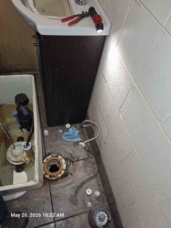 Responded to clogged toilet in office bathroom. Removed and reset toilet to access and clear obstruction in drain line. Pulled toilet, removed old wax ring, cleaned toilet flange, and cleared blockage. Installed new wax ring, reinstalled toilet with proper sealing, reconnected water supply line, and tested for proper flush operation and drainage. Verified no leaks at base or supply connection upon completion.