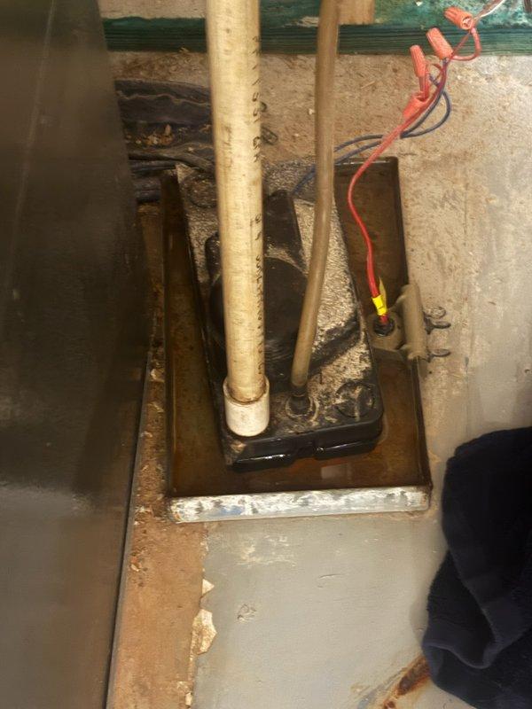 Responded to reported water leak in utility room. Upon arrival, identified source as HVAC condensate drainage issue rather than plumbing leak. Inspected Goodman furnace unit and associated condensate system. Found condensate pump basin with standing water, debris accumulation, and signs of improper drainage. Assessed condition of condensate lines, pump operation, and drain basin functionality. Documented equipment condition and water accumulation patterns around sump basin area for proper diagnosis and recommended corrective action.