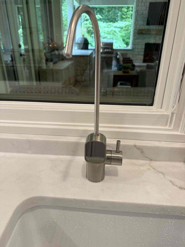 Completed installation of reverse osmosis water filtration system at residential property. Drilled mounting hole through countertop and connected RO system to existing cold water supply line using shut-off valves and appropriate fittings. Installed dedicated RO faucet on sink deck alongside main kitchen faucet, ensuring proper clearance and functionality. Verified all connections for leaks, confirmed system operation, and provided overview of filter maintenance requirements.
