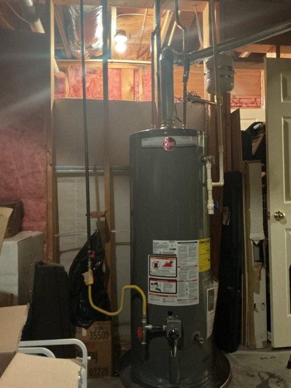 Conducted on-site assessment of existing 50-gallon gas water heater in basement utility area for replacement estimate. Inspected current installation including gas line connections, venting system with flexible ductwork, plumbing connections, and clearance requirements in unfinished basement space with exposed framing and insulation. Documented equipment condition, manufacturer specifications, and existing infrastructure to provide accurate replacement recommendations.