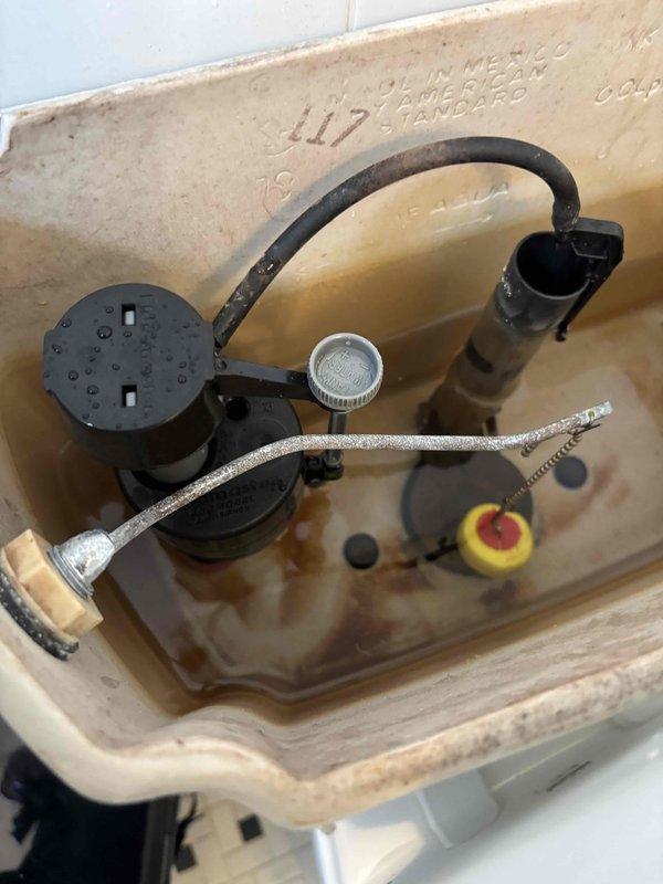 Responded to service call for non-functioning toilet with inoperative flush handle. Upon arrival, found water supply already shut off by customer. Inspected toilet tank components and tested water pressure at 80 PSI using calibrated pressure gauge. Examined American Standard toilet tank interior, identifying worn flush valve assembly and associated hardware requiring attention. Discussed customer-supplied water filtration system installation as additional requested service for future scheduling.