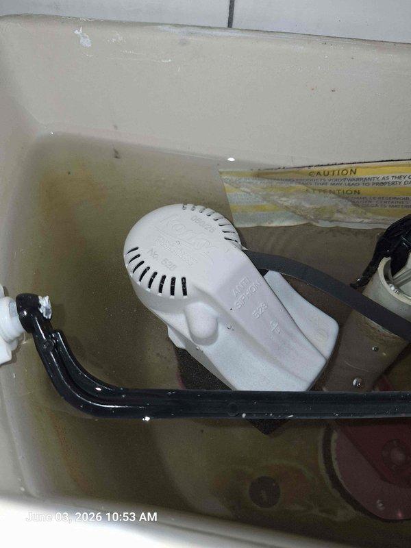 Responded to complaint of running toilet. Upon inspection, found faulty fill valve causing continuous water flow into tank. Water in tank showed significant discoloration due to mineral deposits and sediment buildup. Replaced defective fill valve assembly with new Kohler-compatible unit. Adjusted float mechanism to proper water level. Flushed tank multiple times to clear sediment and verify proper operation. Toilet now fills correctly and shuts off completely without continuous running.