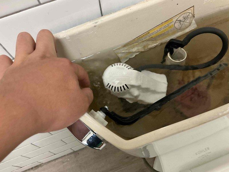 Responded to complaint of running toilet. Upon inspection, found faulty fill valve causing continuous water flow into tank. Water in tank showed significant discoloration due to mineral deposits and sediment buildup. Replaced defective fill valve assembly with new Kohler-compatible unit. Adjusted float mechanism to proper water level. Flushed tank multiple times to clear sediment and verify proper operation. Toilet now fills correctly and shuts off completely without continuous running.