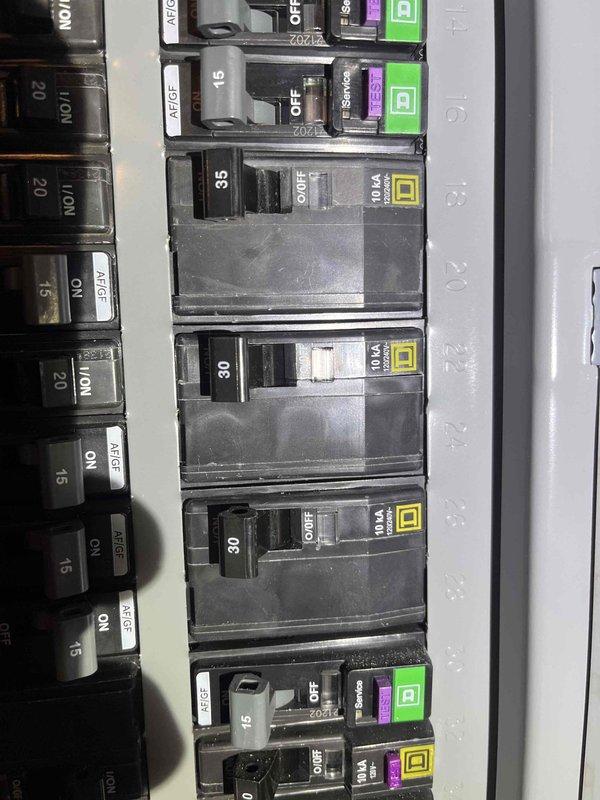 Provided second opinion evaluation of existing HVAC system. Inspected outdoor condenser unit positioned on concrete pad against exterior brick wall, noting older model equipment with visible weathering and age-related wear on cabinet surfaces. Assessed unit's physical condition, mounting location, and clearance requirements for proper airflow. Examined electrical service panel, documenting circuit breaker configuration including multiple 15, 20, 30, and 35 amp breakers serving various building circuits. Photographed equipment and electrical components for documentation purposes. Reviewed system specifications and provided professional assessment to homeowner as requested alternative evaluation.