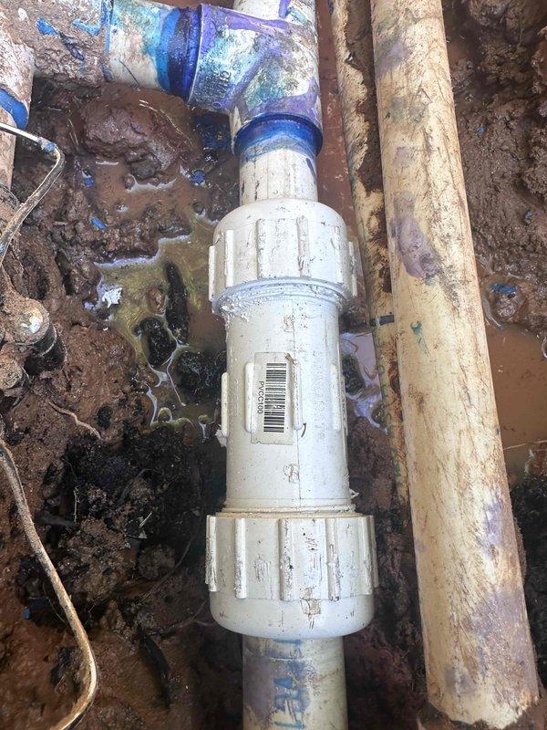 Responded to service call for significant water loss and wet area in yard. Located and excavated underground water line leak at PVC pipe fitting connection. Exposed damaged coupling and T-junction assembly showing signs of deterioration and age-related failure. Repaired compromised pipe connection to restore proper water flow and eliminate leak source.