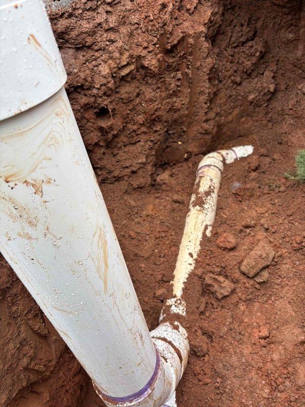 Completed sewer line replacement as specified in approved quote. Excavated trench through clay soil, removed deteriorated existing sewer pipe, and installed new white PVC sewer line with proper fittings and connections. All work performed to code specifications and site restored upon completion.