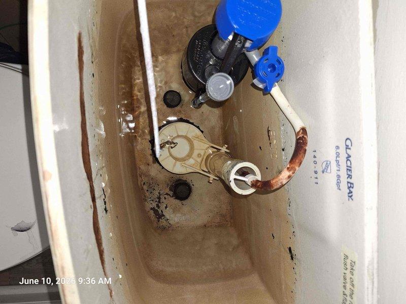 Inspected two toilets with continuous running issues on upper and lower levels of the property. Documented existing plumbing conditions including corroded supply line valves with significant rust and mineral deposits, deteriorated fill valve assemblies with worn components, and flush valve mechanisms showing age-related degradation. Photographed tank interiors revealing substantial mineral buildup, water staining, and corroded internal hardware requiring replacement to resolve constant running conditions.