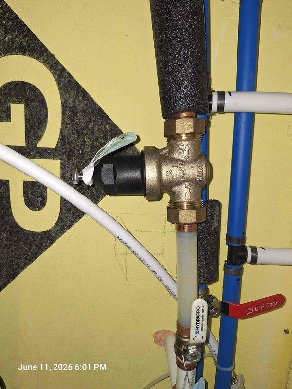 Responded to customer concern regarding hose bibb functionality following recent thermal expansion tank and cartridge service. Upon inspection, documented existing plumbing configuration including main water cutoff valve assembly, brass T-fittings with distribution points, PEX and PVC pipe connections with proper insulation, and red-handled ball valve installation. Verified hose bibb issue appears unrelated to previous work performed on thermal expansion system, as the hose bibb operates on separate branch line from the serviced components.