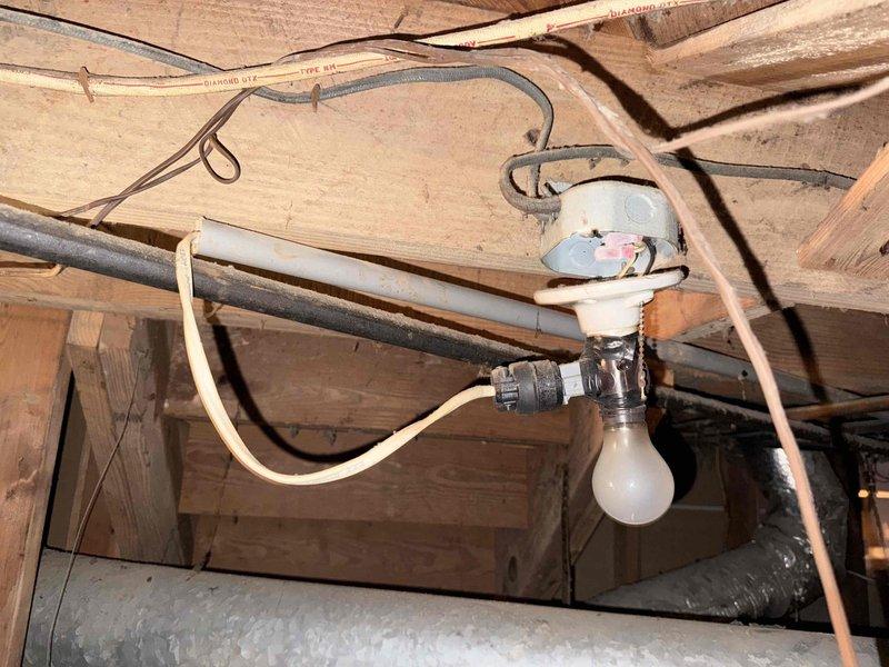 Performed sewer scope inspection of drainage system. Camera inspection revealed floor drain with significant deterioration, heavy black staining, and debris accumulation around drain opening indicating potential blockage or drainage issues. Documented conditions of accessible plumbing infrastructure including crawl space with exposed piping and electrical systems for maintenance records.