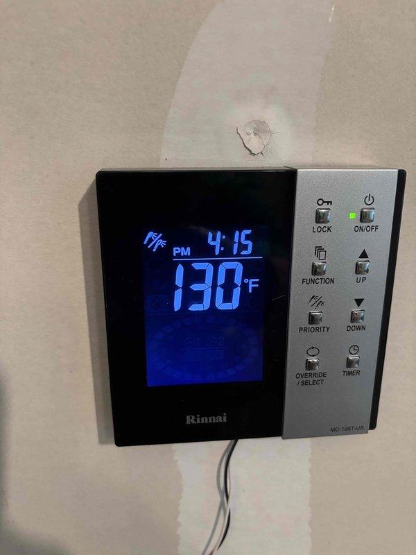Responded to no hot water complaint on Rinnai tankless water heater. Upon inspection, found unit powered on with controller displaying 130°F setpoint but not producing hot water at fixtures. Removed front panel and performed diagnostic inspection of internal components. Identified significant corrosion and oxidation on heat exchanger assembly, indicating potential scale buildup or component failure affecting heat transfer capability. Checked gas valve assemblies, blower motor operation, and electrical connections throughout the unit. Unit was not displaying error codes despite operational failure, suggesting possible sensor malfunction or communication issue between components and controller. Documented current conditions with photos showing corroded heat exchanger and control panel status for further evaluation and repair recommendations.