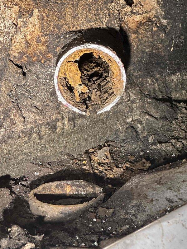 Completed cast iron pipe replacement in deteriorated section showing extensive cracking and structural compromise. Removed failed cast iron drain line with significant corrosion and material degradation around pipe penetration. Installed new piping system to restore proper drainage function and eliminate water damage risk from compromised plumbing infrastructure.