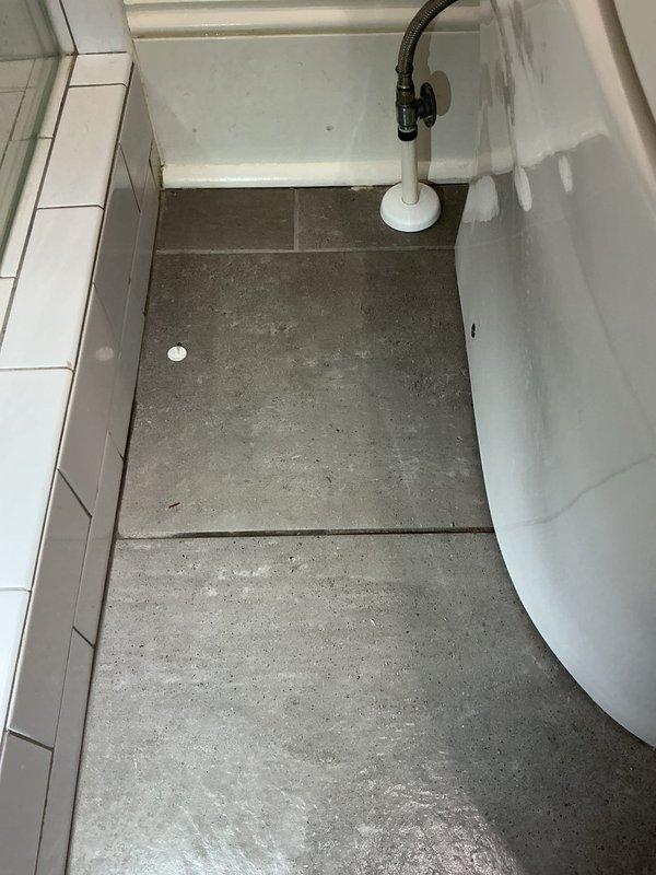 Responded to service call for water pooling around toilet base. Upon arrival, conducted visual inspection of bathroom area and documented conditions with photographs. Inspected toilet fixture, floor surfaces, and surrounding plumbing connections to identify source of water leak. Assessed gray tile flooring for water damage and checked grout lines and baseboard areas for moisture penetration. Examined toilet base seal and mounting hardware for potential failure points causing water escape.