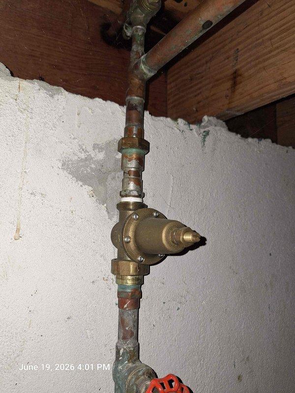 # Ringing Pipes Resolution

Responded to customer complaint of ringing pipes in residential plumbing system. Upon inspection, identified water hammer condition caused by inadequate air chambers and loose pipe mounting. Documented existing corroded brass pressure regulator and aging copper supply lines showing significant oxidation and wear. Secured loose piping runs to ceiling joists with appropriate hangers and added water hammer arrestor to vertical supply line. Tested system under normal flow conditions and verified elimination of noise. Recommended future replacement of corroded fittings and pressure regulator due to advanced deterioration.