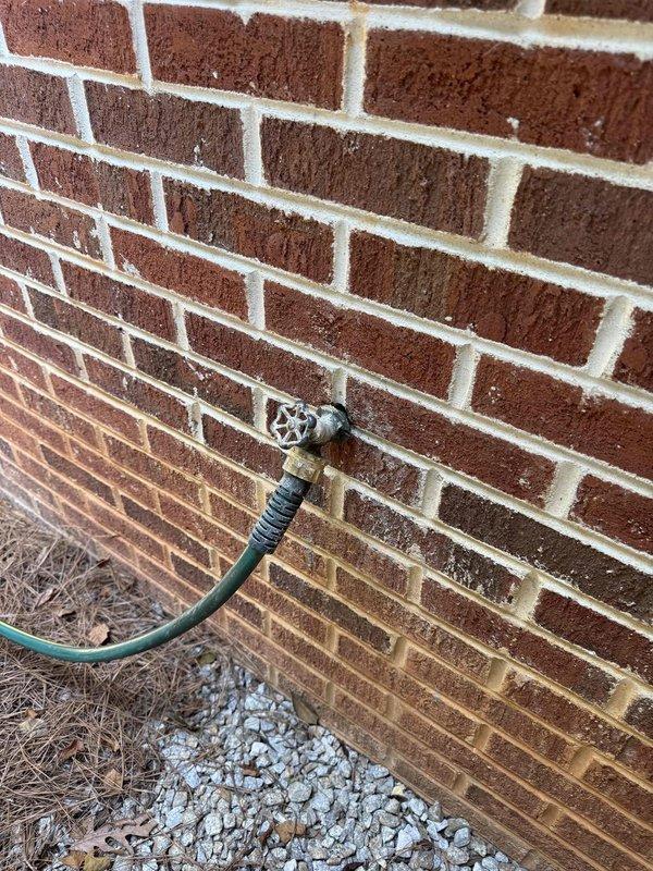 Responded to customer report of leaking hose bib on exterior brick wall. Upon inspection, identified leak at outdoor water spigot connection point where garden hose coupling attached to the fixture. Accessed interior side of hose bib through basement utility area, locating copper supply line running vertically along concrete block wall. Replaced faulty hose bib assembly and verified proper seal at all connection points. Tested system for leaks and confirmed repair resolved the issue with no further water discharge observed at exterior or interior locations.