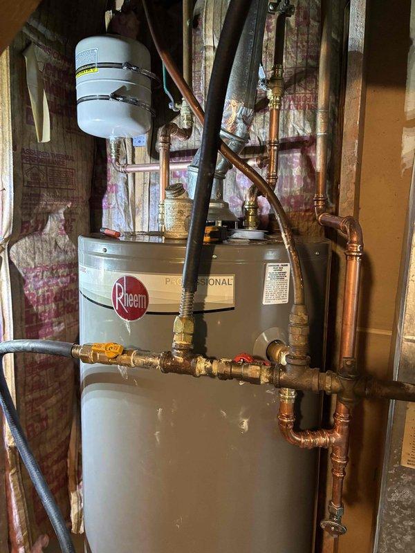 Responded to service call for leaking 50-gallon gas water heater. Upon inspection, determined the existing unit had developed a tank leak and required complete replacement. Removed and properly disposed of the failed water heater in accordance with local regulations.

Installed new Rheem Professional Series 50-gallon gas water heater as replacement. Configured all necessary plumbing connections using copper piping with brass fittings and shut-off valves for both hot and cold water lines. Connected gas supply line with appropriate shut-off valve for safety and code compliance. Installed thermal expansion tank at the top of the unit to protect against excessive pressure buildup in the closed water system.

Verified all connections for proper seal and tested for gas leaks using approved detection methods. Filled tank, purged air from lines, and fired unit to confirm proper ignition and burner operation. Checked temperature and pressure relief valve for proper function. Ensured all safety 