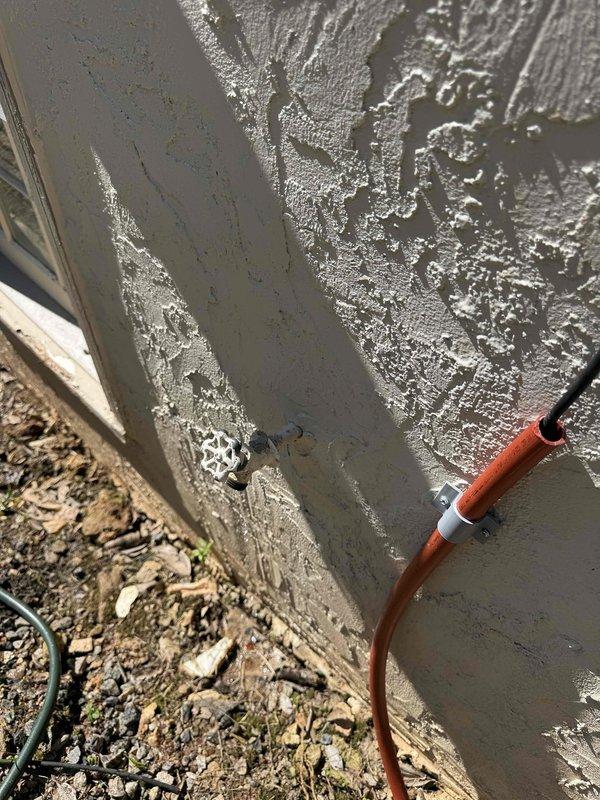 Conducted site assessment for bar sink plumbing extension in residential space. Evaluated interior room layout and exterior foundation access points to determine optimal routing for water supply and drain lines. Documented existing conditions including interior wall configuration, flooring, and exterior foundation wall with current utility penetrations to develop installation plan for new plumbing rough-in.