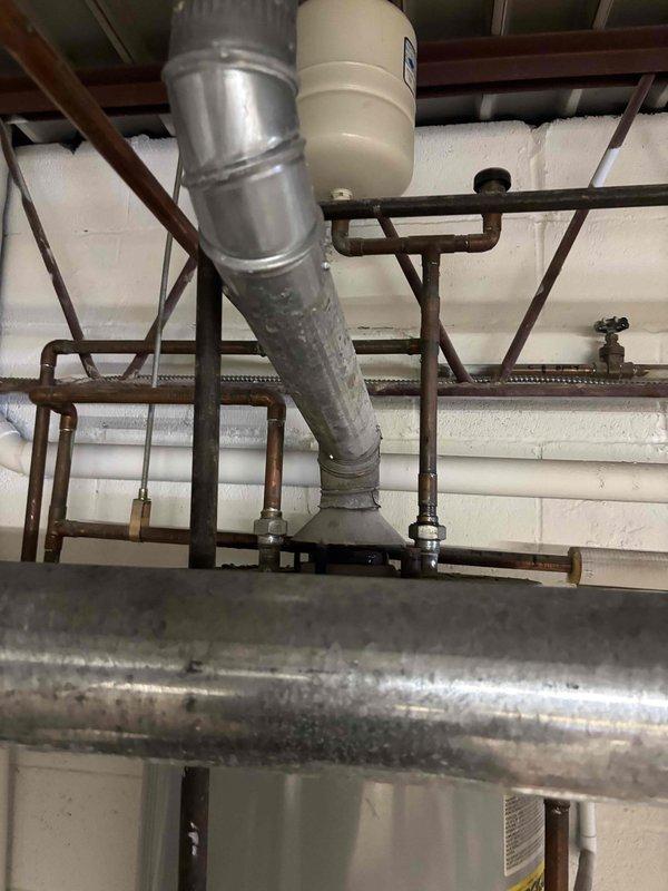 Responded to leak on 1-inch copper water line in basement utility area. Upon arrival, inspected the piping system which included a network of copper and galvanized pipes with multiple valves, fittings, and connection points showing signs of age and oxidation. Located the source of the leak at a compromised section of the copper line. Shut off water supply using existing gate valves to isolate the affected section. Removed the damaged portion of copper pipe and prepared pipe ends for repair. Installed new copper pipe section using proper fittings and connections. Soldered joints to ensure watertight seal. Restored water supply and pressure tested the repair to verify no leaks present. Confirmed all connections were secure and system was functioning properly before completing the service call.