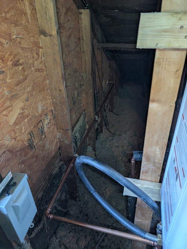 Completed follow-up inspection and service on tankless gas water heater system and temperature and pressure relief valve. Accessed rooftop area to inspect gas line routing and venting configuration for tankless unit. Examined exterior wall penetration where gas supply line enters structure, noting exposed framing at roof-to-wall junction that required documentation. 

Proceeded to interior mechanical space with exposed framing to verify proper installation of gas piping and water connections. Inspected copper water supply lines and blue flexible gas connector line running to tankless water heater location. Confirmed T&P relief valve installation and discharge piping meet code requirements. Verified all connections are secure and system is operating within manufacturer specifications. Documented conditions with photographs for service records.