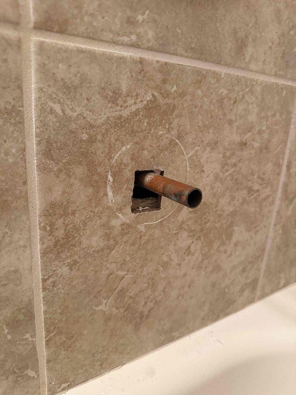 Responded to service call for multiple plumbing issues throughout the residence. Addressed slow-draining basement bathroom sink by clearing obstruction from drain line. Inspected master bathroom trap and identified improper leveling causing drainage concerns. 

In separate bathroom, diagnosed malfunctioning tub/shower diverter that was failing to redirect water flow to shower head. Found diverter mechanism loose and not engaging properly. Removed existing diverter spout and prepared copper stub-out for replacement fixture installation. Photographed exposed copper pipe extending from tiled wall to document condition and verify proper positioning for new diverter assembly.

Performed requested inspection of water heater and confirmed unit operating within normal parameters with no active issues or safety concerns identified at time of service. All affected fixtures and systems evaluated and findings documented with photographic evidence.