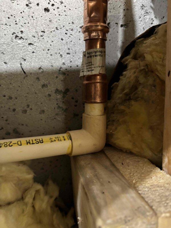 Responded to pressure issue following recent remodel work. Inspected plumbing installation in basement/utility area, documenting vertical PVC riser with copper fittings and compression couplings, as well as CPVC pipe connections with elbow joints. Previous contractor's work required evaluation to identify source of pressure problems affecting the system.