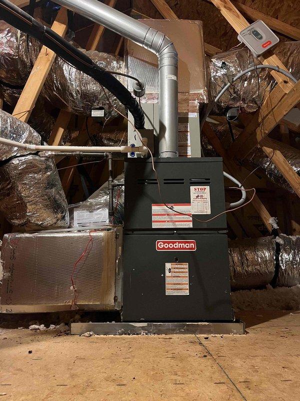 Replaced failed evaporator coil on Goodman furnace system in attic installation. Removed corroded coil assembly showing extensive rust damage at connection points and base, installed new coil unit, and reconnected refrigerant lines and ductwork to restore proper system operation.
