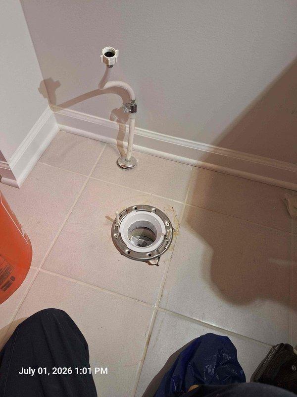 Responded to service call for two toilet flange issues and discolored water from rarely used bathtubs. Assessed existing toilet flange condition and discussed drilling out old flange for new installation, similar to previous toilet repair work completed at property. Removed toilet and evaluated flange mounting options for secure reinstallation. Addressed brown water concern in bathtubs, likely caused by sediment buildup and stagnant water in supply lines from infrequent use. Documented conditions with photos showing flange removal process, supply line configuration, and floor-mounted drain assembly with chrome hardware. Provided recommendations for flange replacement procedure and flushing protocol for affected bathtub fixtures to clear discolored water.