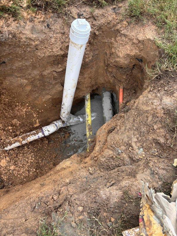 Completed full sewer and water line replacement at residential property. Excavated trench approximately 2-3 feet deep through clay-based soil to access existing utility lines. Removed old piping and installed new white PVC water supply line and sewer drain lines with proper fittings and connections. Verified proper depth and grade for drainage using measuring equipment. All new plumbing connections were assembled and tested at junction points. Excavation work included careful trenching to preserve surrounding lawn areas where possible, with clean vertical trench walls maintained throughout the installation process. Completed full sewer and water line replacement at residential property. Excavated trench approximately 2-3 feet deep through clay-based soil to access existing utility lines. Removed old piping and installed new white PVC water supply line and sewer drain lines with proper fittings and connections. Verified proper depth and grade for drainage using measuring equipment. All new plumbing connections were assembled and tested at junction points. Excavation work included careful trenching to preserve surrounding lawn areas where possible, with clean vertical trench walls maintained throughout the installation process.