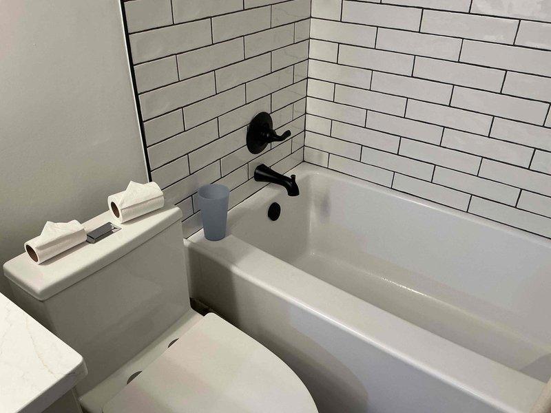 Responded to service call for bathtub not receiving hot water. Upon inspection, discovered low water pressure issue affecting hot water delivery to tub fixtures. Checked pressure gauge on main water line, which indicated readings below normal operating range. Diagnosed and resolved pressure regulation problem at the supply valve. Tested black matte wall-mounted tub spout and diverter handle to verify proper hot water flow and temperature. Confirmed all fixtures operating correctly with adequate pressure and temperature before completing service.