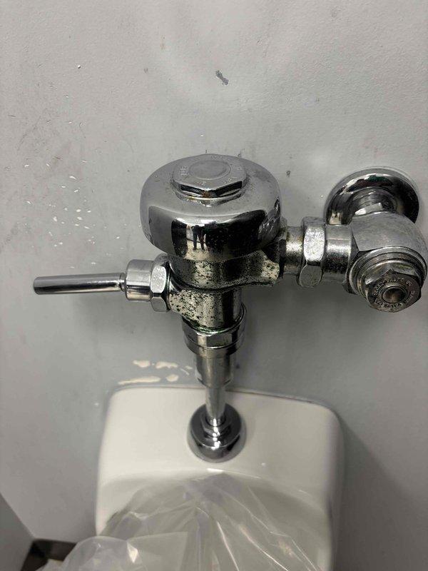 Responded to multiple plumbing issues including sink faucet leaking from handle, base leak on secondary faucet, and malfunctioning sprayer that would not shut off properly. Inspected and serviced men's urinal with slow flushing issue, examining the flush valve assembly and internal components. Documented all fixtures with photographs showing the urinal's 0.5 gallon per flush Kohler system and chrome flush valve mechanism for service records. Responded to multiple plumbing issues including sink faucet leaking from handle, base leak on secondary faucet, and malfunctioning sprayer that would not shut off properly. Inspected and serviced men's urinal with slow flushing issue, examining the flush valve assembly and internal components. Documented all fixtures with photographs showing the urinal's 0.5 gallon per flush Kohler system and chrome flush valve mechanism for service records.