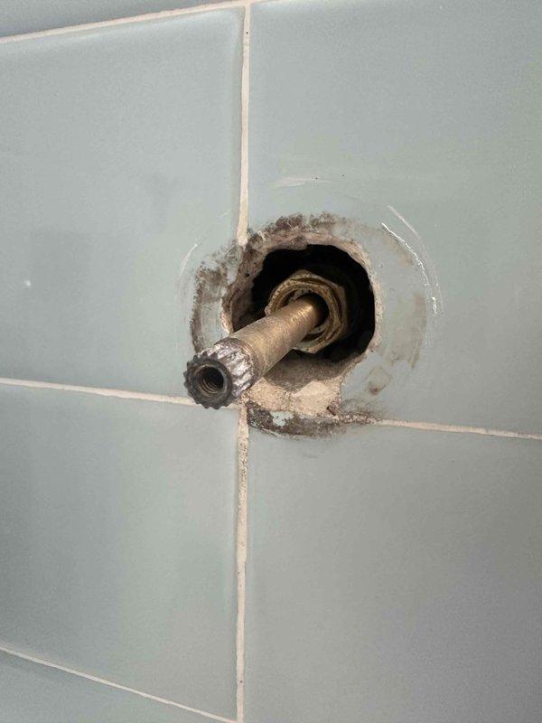 Responded to service call for leaking bathroom shower faucet and performed routine tankless water heater inspection with complimentary flush service. Removed deteriorated Gerber shower valve handle and stem assembly from tiled shower wall, which showed significant mineral buildup and corrosion around the fixture opening. Completed scheduled maintenance on tankless water heater system as part of customer's annual service plan. Responded to service call for leaking bathroom shower faucet and performed routine tankless water heater inspection with complimentary flush service. Removed deteriorated Gerber shower valve handle and stem assembly from tiled shower wall, which showed significant mineral buildup and corrosion around the fixture opening. Completed scheduled maintenance on tankless water heater system as part of customer's annual service plan.