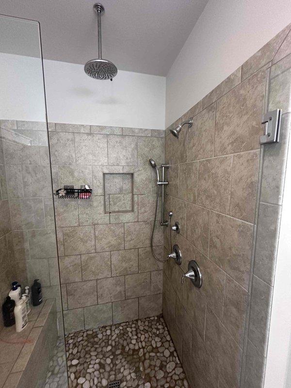 Responded to report of two non-functioning sinks in bathroom. Upon inspection, determined the issue was related to the shower fixture system rather than separate sink fixtures. Evaluated the chrome shower control valves and tub spout assembly mounted on the tiled wall. Assessed water flow and pressure through both the overhead rainfall showerhead and handheld shower unit on the slide bar. Tested all control mechanisms to verify proper operation and restored full functionality to the shower system. Responded to report of two non-functioning sinks in bathroom. Upon inspection, determined the issue was related to the shower fixture system rather than separate sink fixtures. Evaluated the chrome shower control valves and tub spout assembly mounted on the tiled wall. Assessed water flow and pressure through both the overhead rainfall showerhead and handheld shower unit on the slide bar. Tested all control mechanisms to verify proper operation and restored full functionality to the shower system.