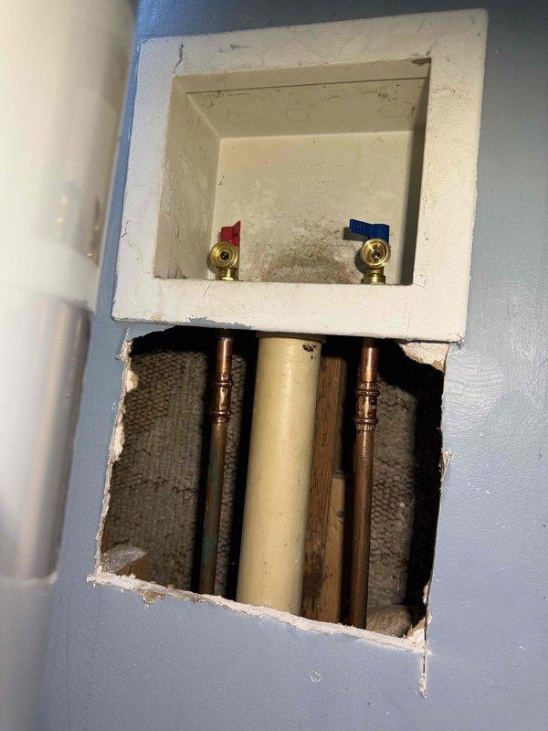 Responded to service call for corroded washer water valve. Upon inspection, found existing brass shut-off valves with red and blue handles showing signs of age and corrosion. Documented current condition of plumbing infrastructure, including valve assembly, flexible braided supply lines, and associated copper and PVC piping within wall cavity. Photographed valve box assembly and exposed plumbing access point for service records and customer reference. Responded to service call for corroded washer water valve. Upon inspection, found existing brass shut-off valves with red and blue handles showing signs of age and corrosion. Documented current condition of plumbing infrastructure, including valve assembly, flexible braided supply lines, and associated copper and PVC piping within wall cavity. Photographed valve box assembly and exposed plumbing access point for service records and customer reference.