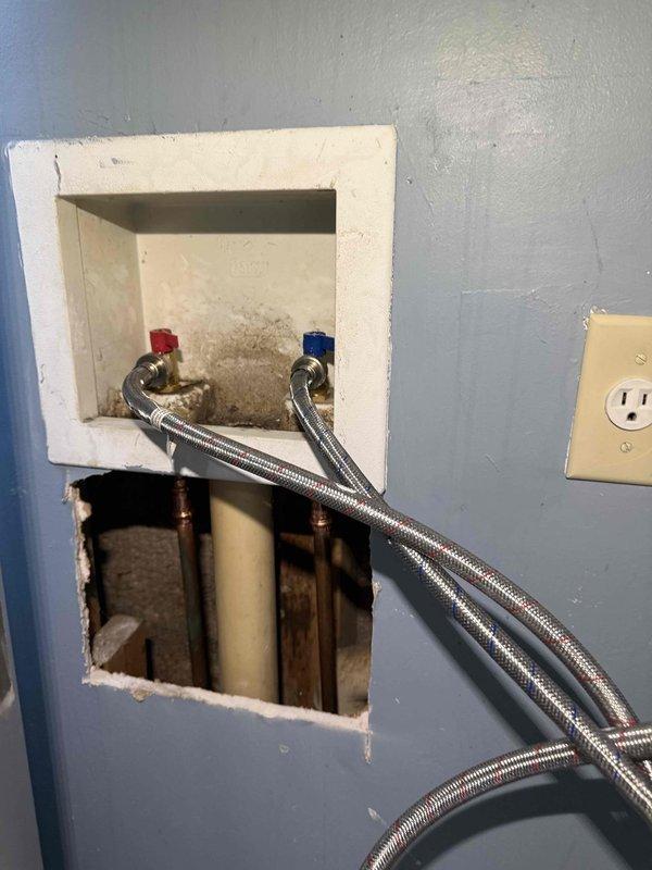 Responded to service call for corroded washer water valve. Upon inspection, found existing brass shut-off valves with red and blue handles showing signs of age and corrosion. Documented current condition of plumbing infrastructure, including valve assembly, flexible braided supply lines, and associated copper and PVC piping within wall cavity. Photographed valve box assembly and exposed plumbing access point for service records and customer reference. Responded to service call for corroded washer water valve. Upon inspection, found existing brass shut-off valves with red and blue handles showing signs of age and corrosion. Documented current condition of plumbing infrastructure, including valve assembly, flexible braided supply lines, and associated copper and PVC piping within wall cavity. Photographed valve box assembly and exposed plumbing access point for service records and customer reference.