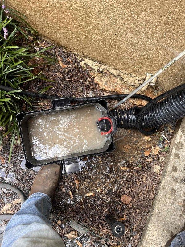 Conducted free estimate for clogged drainage line. Inspected HVAC condensate system in basement utility area and exterior discharge point at building foundation. Documented PVC drainage assembly, condensate collection pan with standing water, and flexible discharge hose configuration to assess blockage location and recommend appropriate clearing solution.