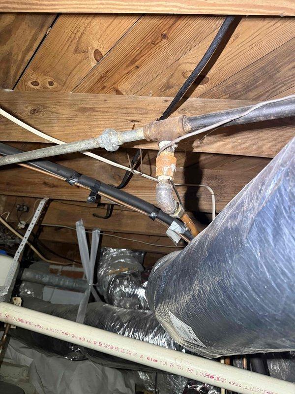 Completed consultation and assessment for conversion from existing gas-fired tank-style water heater to tankless system. Evaluated current installation including gas supply line, venting configuration through attic space, electrical requirements, and existing plumbing connections. Inspected galvanized and copper supply piping, expansion tank, shutoff valves, and available clearances in mechanical room. Assessed gas line capacity, existing flue pipe routing through ceiling joists, and structural considerations for mounting tankless unit. Documented current water heater specifications and mechanical room layout. Provided recommendations for tankless water heater installation including necessary upgrades to gas piping, venting modifications, electrical service requirements, and optimal unit placement for code compliance and efficient operation. Completed consultation and assessment for conversion from existing gas-fired tank-style water heater to tankless system. Evaluated current installation including gas supply line, venting configuration through attic space, electrical requirements, and existing plumbing connections. Inspected galvanized and copper supply piping, expansion tank, shutoff valves, and available clearances in mechanical room. Assessed gas line capacity, existing flue pipe routing through ceiling joists, and structural considerations for mounting tankless unit. Documented current water heater specifications and mechanical room layout. Provided recommendations for tankless water heater installation including necessary upgrades to gas piping, venting modifications, electrical service requirements, and optimal unit placement for code compliance and efficient operation.