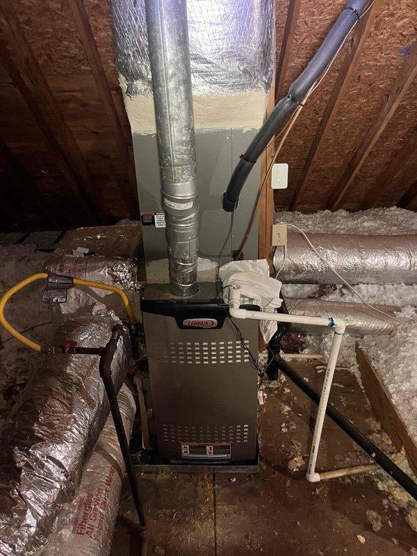 Responded to service call for HVAC system with active leak from main drain line. Upon inspection of attic-installed Lennox furnace unit, confirmed previous repair attempt was unsuccessful and leak persisted from within the unit. Examined white plastic condensate drain assembly and evaporator coil system to identify source of water discharge. Photographed installation showing ductwork configuration, refrigerant lines, and coil assembly with visible dust accumulation on aluminum fins. Documented condition of condensate drainage components and internal coil housing to determine appropriate repair solution for ongoing water leak issue. Responded to service call for HVAC system with active leak from main drain line. Upon inspection of attic-installed Lennox furnace unit, confirmed previous repair attempt was unsuccessful and leak persisted from within the unit. Examined white plastic condensate drain assembly and evaporator coil system to identify source of water discharge. Photographed installation showing ductwork configuration, refrigerant lines, and coil assembly with visible dust accumulation on aluminum fins. Documented condition of condensate drainage components and internal coil housing to determine appropriate repair solution for ongoing water leak issue.
