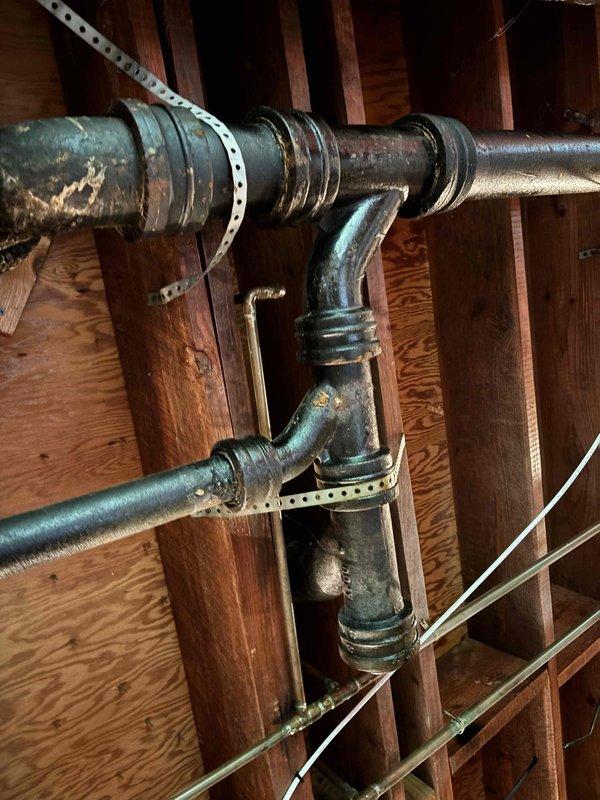 Responded to low water pressure complaint affecting all fixtures throughout residence. Upon inspection, identified aging galvanized piping system as primary concern, with specific blockage or restriction detected in washing machine supply line. Documented existing plumbing infrastructure including cast iron drain lines and copper supply piping with visible corrosion and patina buildup. Observed pressure regulator and shutoff valves in crawl space area showing signs of age-related deterioration. Photographed piping configuration and condition for service records. Responded to low water pressure complaint affecting all fixtures throughout residence. Upon inspection, identified aging galvanized piping system as primary concern, with specific blockage or restriction detected in washing machine supply line. Documented existing plumbing infrastructure including cast iron drain lines and copper supply piping with visible corrosion and patina buildup. Observed pressure regulator and shutoff valves in crawl space area showing signs of age-related deterioration. Photographed piping configuration and condition for service records.
