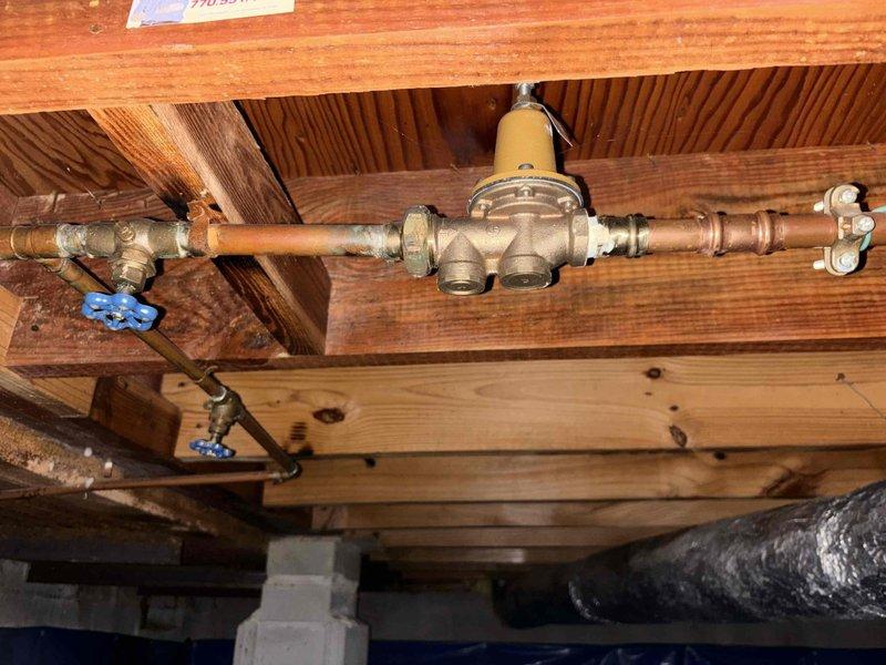 Responded to low water pressure complaint affecting all fixtures throughout residence. Upon inspection, identified aging galvanized piping system as primary concern, with specific blockage or restriction detected in washing machine supply line. Documented existing plumbing infrastructure including cast iron drain lines and copper supply piping with visible corrosion and patina buildup. Observed pressure regulator and shutoff valves in crawl space area showing signs of age-related deterioration. Photographed piping configuration and condition for service records. Responded to low water pressure complaint affecting all fixtures throughout residence. Upon inspection, identified aging galvanized piping system as primary concern, with specific blockage or restriction detected in washing machine supply line. Documented existing plumbing infrastructure including cast iron drain lines and copper supply piping with visible corrosion and patina buildup. Observed pressure regulator and shutoff valves in crawl space area showing signs of age-related deterioration. Photographed piping configuration and condition for service records.