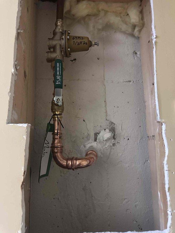 Completed water service installation including pressure regulator and ball valve assembly with copper piping in wall cavity. Installed wall-mounted cabinet in corner location to provide access panel for plumbing components. Completed water service installation including pressure regulator and ball valve assembly with copper piping in wall cavity. Installed wall-mounted cabinet in corner location to provide access panel for plumbing components.