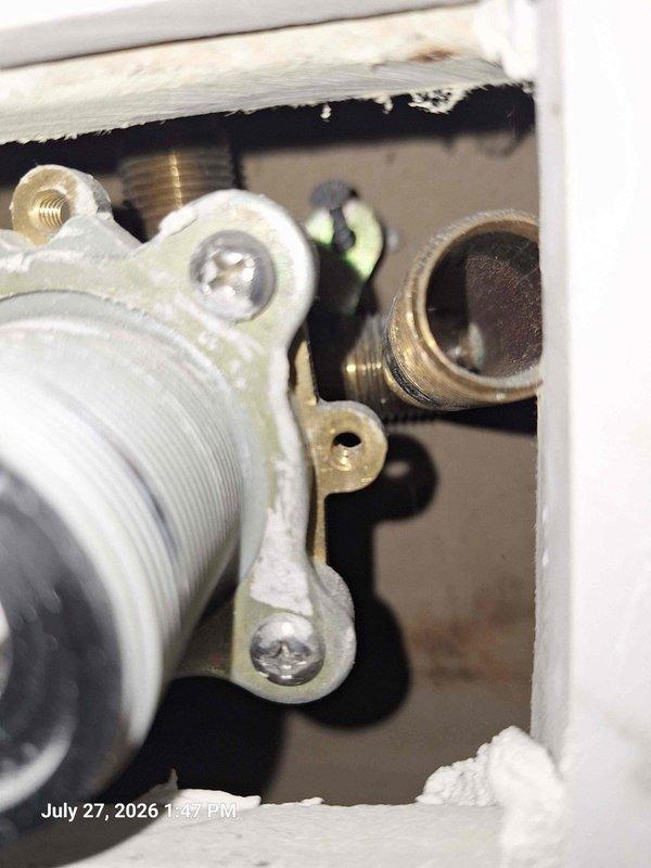 Responded to plumbing issue where back main shower was not receiving cold water and front shower was not receiving hot water. Upon inspection, accessed wall cavities at both shower locations to examine valve assemblies and supply line connections. Identified crossed or improperly connected hot and cold water supply lines serving the two shower fixtures. Documented existing plumbing configuration showing white plastic threaded connectors, brass valve bodies, and supply piping within wall openings. Traced water supply lines to determine correct routing for proper hot and cold water delivery to each shower location. Issue resolved by correcting the supply line connections to restore proper hot and cold water flow to both showers. Responded to plumbing issue where back main shower was not receiving cold water and front shower was not receiving hot water. Upon inspection, accessed wall cavities at both shower locations to examine valve assemblies and supply line connections. Identified crossed or improperly connected hot and cold water supply lines serving the two shower fixtures. Documented existing plumbing configuration showing white plastic threaded connectors, brass valve bodies, and supply piping within wall openings. Traced water supply lines to determine correct routing for proper hot and cold water delivery to each shower location. Issue resolved by correcting the supply line connections to restore proper hot and cold water flow to both showers.