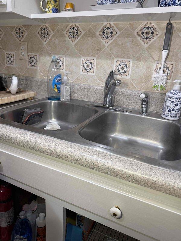 Removed kitchen faucet and capped off hot and cold water supply lines in preparation for customer's kitchen remodeling project. Shut off water supply valves, disconnected faucet from supply lines, removed single-handle chrome faucet from double-basin sink, and properly capped both water lines to prevent leaks during the remodeling phase. Work area left clean and secure, with water supply valves accessible for future reopening when customer is ready to install new faucet upon completion of remodel.