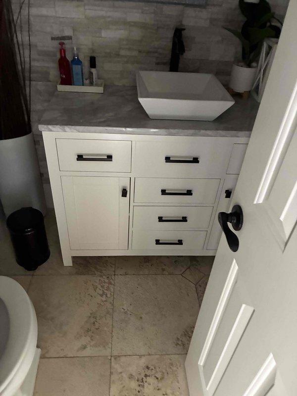 Responded to customer concern regarding hot bathroom floor tile indicating potential leak. Conducted thorough inspection of bathroom vanity plumbing, kitchen sink connections, and surrounding areas. Inspected all visible water supply lines, drain connections, and shut-off valves for signs of moisture, corrosion, or active leaks. Checked beneath vanity cabinet and kitchen sink base for water damage or dampness. Documented conditions with photographs showing no visible water intrusion, staining, or moisture damage to cabinetry, flooring, or surrounding areas. Advised customer that hot floor tile may be caused by hot water supply line routing beneath flooring or radiant heating system rather than active leak, as no evidence of water leakage was detected during inspection. Responded to customer concern regarding hot bathroom floor tile indicating potential leak. Conducted thorough inspection of bathroom vanity plumbing, kitchen sink connections, and surrounding areas. Inspected all visible water supply lines, drain connections, and shut-off valves for signs of moisture, corrosion, or active leaks. Checked beneath vanity cabinet and kitchen sink base for water damage or dampness. Documented conditions with photographs showing no visible water intrusion, staining, or moisture damage to cabinetry, flooring, or surrounding areas. Advised customer that hot floor tile may be caused by hot water supply line routing beneath flooring or radiant heating system rather than active leak, as no evidence of water leakage was detected during inspection.