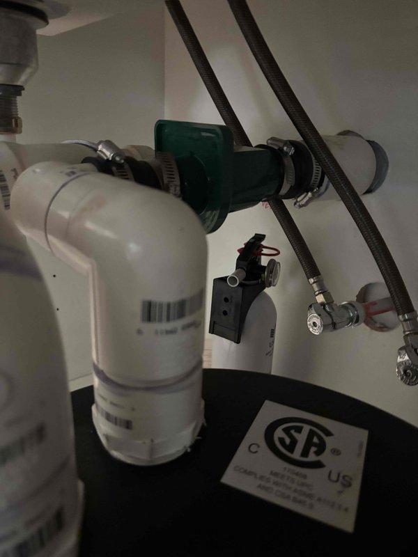 # Leak Repair - Under-Sink Plumbing
Responded to service call for leaking pump beneath kitchen sink. Upon inspection, identified leak originating from connections on water filtration system with multiple filter housings and green valve assembly. Inspected all PVC piping, P-trap configuration, braided stainless steel supply lines, and compression fittings for signs of water intrusion. Tightened metal hose clamps securing connections to green cylindrical component and verified proper seal on filter housing O-rings. Checked all shut-off valves and supply line connections for proper torque and alignment. Tested system under pressure to confirm leak was eliminated and all components functioning correctly. # Leak Repair - Under-Sink Plumbing
Responded to service call for leaking pump beneath kitchen sink. Upon inspection, identified leak originating from connections on water filtration system with multiple filter housings and green valve assembly. Inspected all PVC piping, P-trap configuration, braided stainless steel supply lines, and compression fittings for signs of water intrusion. Tightened metal hose clamps securing connections to green cylindrical component and verified proper seal on filter housing O-rings. Checked all shut-off valves and supply line connections for proper torque and alignment. Tested system under pressure to confirm leak was eliminated and all components functioning correctly.