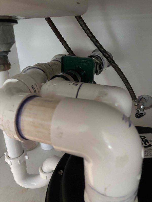# Leak Repair - Under-Sink Plumbing
Responded to service call for leaking pump beneath kitchen sink. Upon inspection, identified leak originating from connections on water filtration system with multiple filter housings and green valve assembly. Inspected all PVC piping, P-trap configuration, braided stainless steel supply lines, and compression fittings for signs of water intrusion. Tightened metal hose clamps securing connections to green cylindrical component and verified proper seal on filter housing O-rings. Checked all shut-off valves and supply line connections for proper torque and alignment. Tested system under pressure to confirm leak was eliminated and all components functioning correctly. # Leak Repair - Under-Sink Plumbing
Responded to service call for leaking pump beneath kitchen sink. Upon inspection, identified leak originating from connections on water filtration system with multiple filter housings and green valve assembly. Inspected all PVC piping, P-trap configuration, braided stainless steel supply lines, and compression fittings for signs of water intrusion. Tightened metal hose clamps securing connections to green cylindrical component and verified proper seal on filter housing O-rings. Checked all shut-off valves and supply line connections for proper torque and alignment. Tested system under pressure to confirm leak was eliminated and all components functioning correctly.