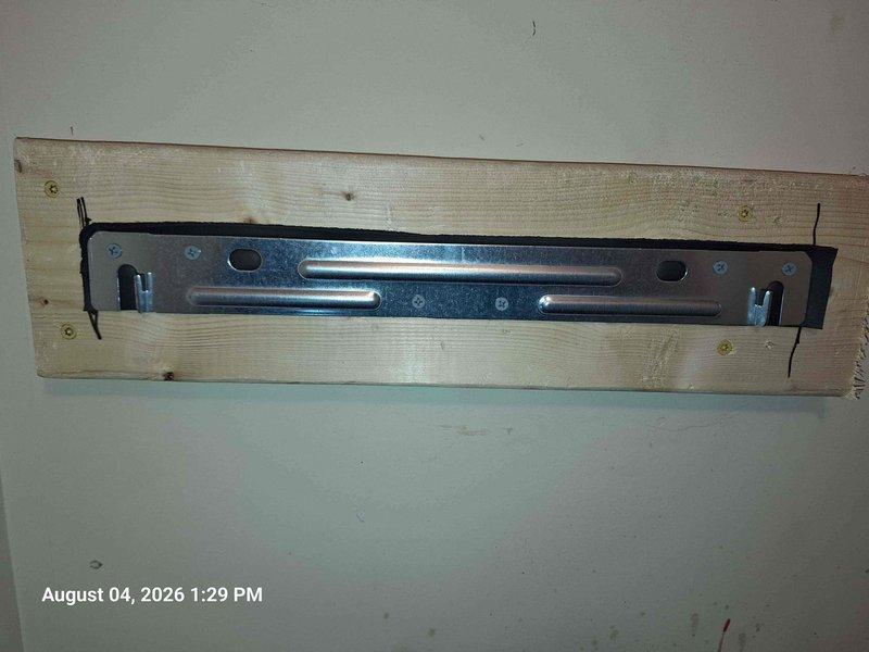 Completed water heater installation with proper venting and mounting system. Installed galvanized steel mounting bracket on wooden backing board secured to interior wall for equipment support. Set up dual PVC intake and exhaust venting system with proper terminations, including screened intake vent to prevent debris entry. All piping secured with metal band clamps at connection points and mounted on base plates with appropriate wall blocking for structural support. Venting system routed horizontally with proper pitch and vertical terminations meeting manufacturer specifications for condensing water heater applications. Completed water heater installation with proper venting and mounting system. Installed galvanized steel mounting bracket on wooden backing board secured to interior wall for equipment support. Set up dual PVC intake and exhaust venting system with proper terminations, including screened intake vent to prevent debris entry. All piping secured with metal band clamps at connection points and mounted on base plates with appropriate wall blocking for structural support. Venting system routed horizontally with proper pitch and vertical terminations meeting manufacturer specifications for condensing water heater applications.