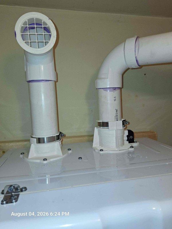 Completed water heater installation with proper venting and mounting system. Installed galvanized steel mounting bracket on wooden backing board secured to interior wall for equipment support. Set up dual PVC intake and exhaust venting system with proper terminations, including screened intake vent to prevent debris entry. All piping secured with metal band clamps at connection points and mounted on base plates with appropriate wall blocking for structural support. Venting system routed horizontally with proper pitch and vertical terminations meeting manufacturer specifications for condensing water heater applications. Completed water heater installation with proper venting and mounting system. Installed galvanized steel mounting bracket on wooden backing board secured to interior wall for equipment support. Set up dual PVC intake and exhaust venting system with proper terminations, including screened intake vent to prevent debris entry. All piping secured with metal band clamps at connection points and mounted on base plates with appropriate wall blocking for structural support. Venting system routed horizontally with proper pitch and vertical terminations meeting manufacturer specifications for condensing water heater applications.