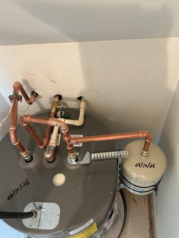 Installed low boy water heater in utility closet with complete plumbing connections. Configured copper piping with proper loop system, installed expansion tank, connected pressure relief valve, and established hot and cold water lines with appropriate shut-off valves. Completed electrical junction box wiring, attached flexible discharge hose, and secured all piping with wall-mounted brackets. System tested and verified operational. Installed low boy water heater in utility closet with complete plumbing connections. Configured copper piping with proper loop system, installed expansion tank, connected pressure relief valve, and established hot and cold water lines with appropriate shut-off valves. Completed electrical junction box wiring, attached flexible discharge hose, and secured all piping with wall-mounted brackets. System tested and verified operational.