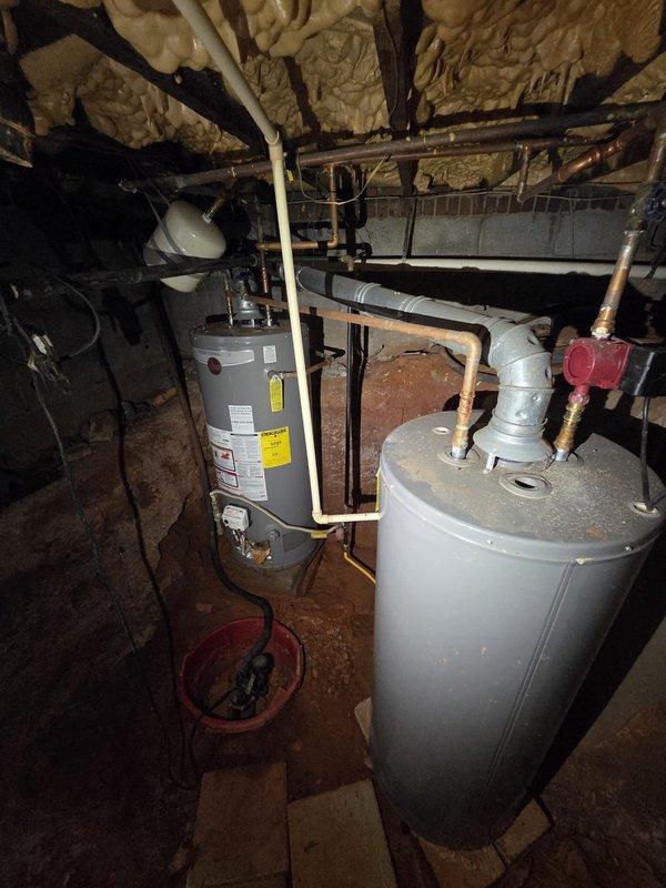 Responded to service call for leaking 40-gallon gas water heater installed in 2017. Upon inspection, confirmed active leak at bottom of tank indicating internal tank failure. Documented existing dual water heater installation with overhead expansion tank and copper supply lines. Photographed equipment condition and surrounding mechanical systems to provide estimate for water heater replacement. Responded to service call for leaking 40-gallon gas water heater installed in 2017. Upon inspection, confirmed active leak at bottom of tank indicating internal tank failure. Documented existing dual water heater installation with overhead expansion tank and copper supply lines. Photographed equipment condition and surrounding mechanical systems to provide estimate for water heater replacement.