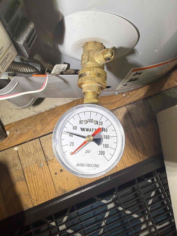 Responded to complaint of low water pressure in shower fluctuating between 39-41 PSI throughout the day. Upon inspection, verified pressure readings at the water heater using installed pressure gauge, which confirmed suboptimal pressure levels below the recommended residential range of 45-60 PSI. Documented existing pressure monitoring equipment and plumbing configuration including pressure reducing valve assembly with brass fittings and shutoff valves. Inspected shower fixture and verified chrome shower head installation on curved supply pipe with white subway tile surround showing no visible obstructions or mineral buildup that would restrict flow. Photographed pressure gauge readings and shower installation for service records to establish baseline measurements for pressure system evaluation. Responded to complaint of low water pressure in shower fluctuating between 39-41 PSI throughout the day. Upon inspection, verified pressure readings at the water heater using installed pressure gauge, which confirmed suboptimal pressure levels below the recommended residential range of 45-60 PSI. Documented existing pressure monitoring equipment and plumbing configuration including pressure reducing valve assembly with brass fittings and shutoff valves. Inspected shower fixture and verified chrome shower head installation on curved supply pipe with white subway tile surround showing no visible obstructions or mineral buildup that would restrict flow. Photographed pressure gauge readings and shower installation for service records to establish baseline measurements for pressure system evaluation.